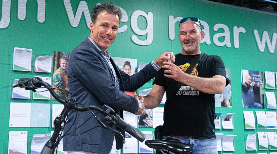 HR directeur Peter Vossen geeft een fietssleutel aan een Ergon collega.